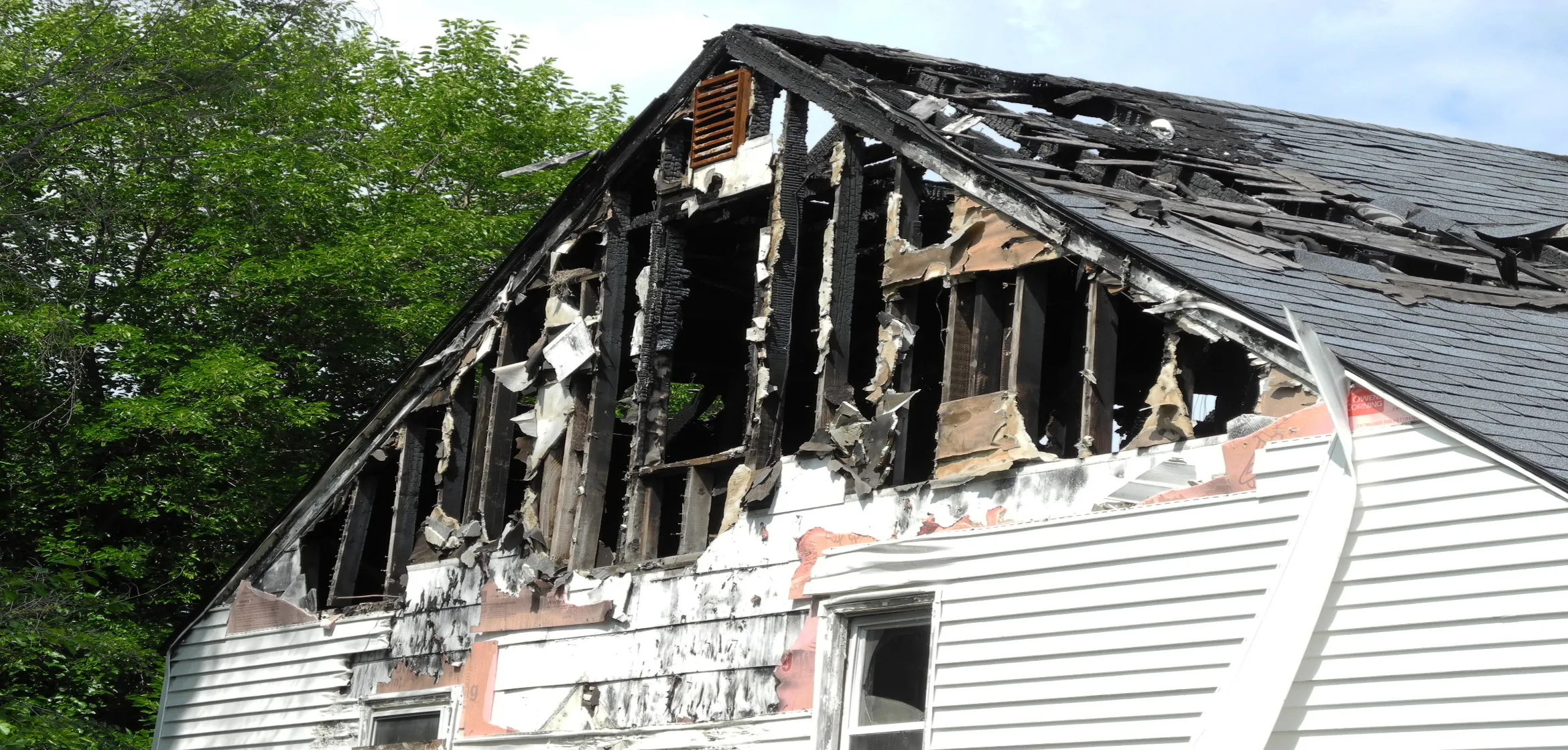 Fire and smoke damage to a residential home in Dallas showing charred framing and roof damage