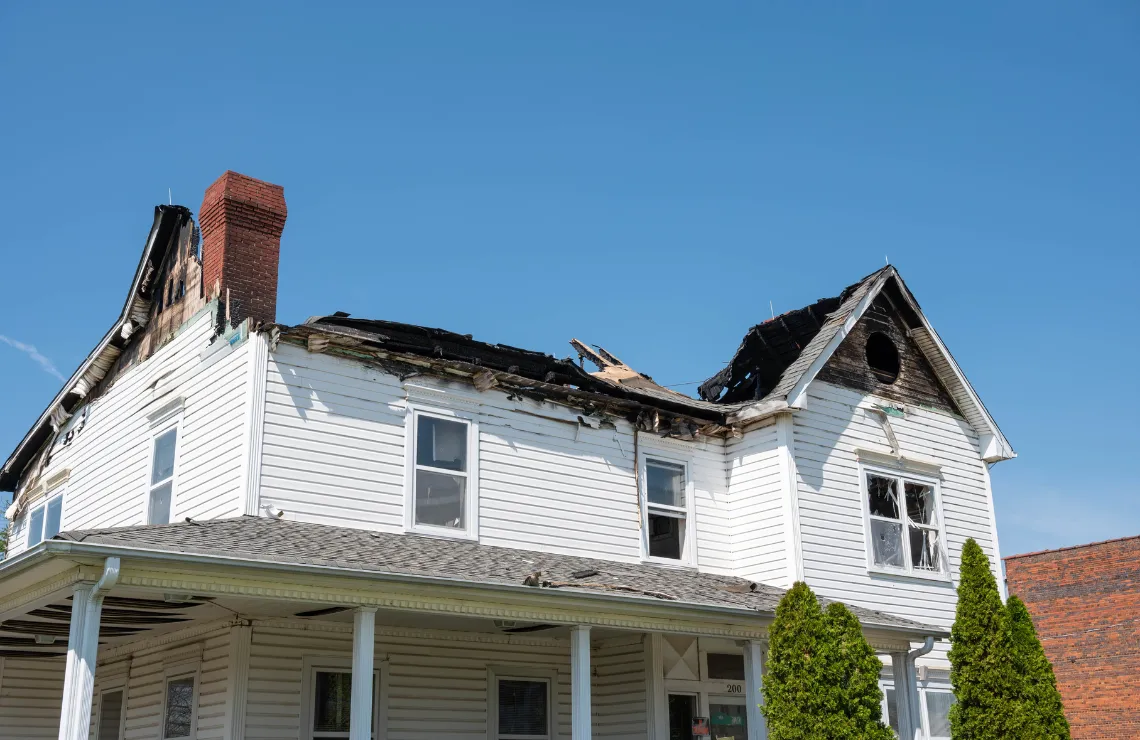 Severely fire-damaged two-story home before full reconstruction services in Dallas